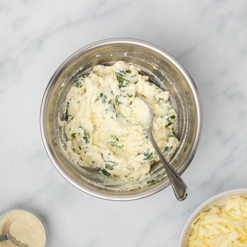 Same mixing bowl with mozzarella and fresh chopped basil mixed in