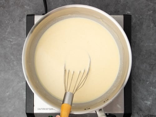 same whisk in same saucepan with pale yellow liquid