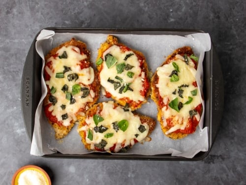 same casserole dish with same cutlets with cheese melted and some more fresh chopped basil leaves