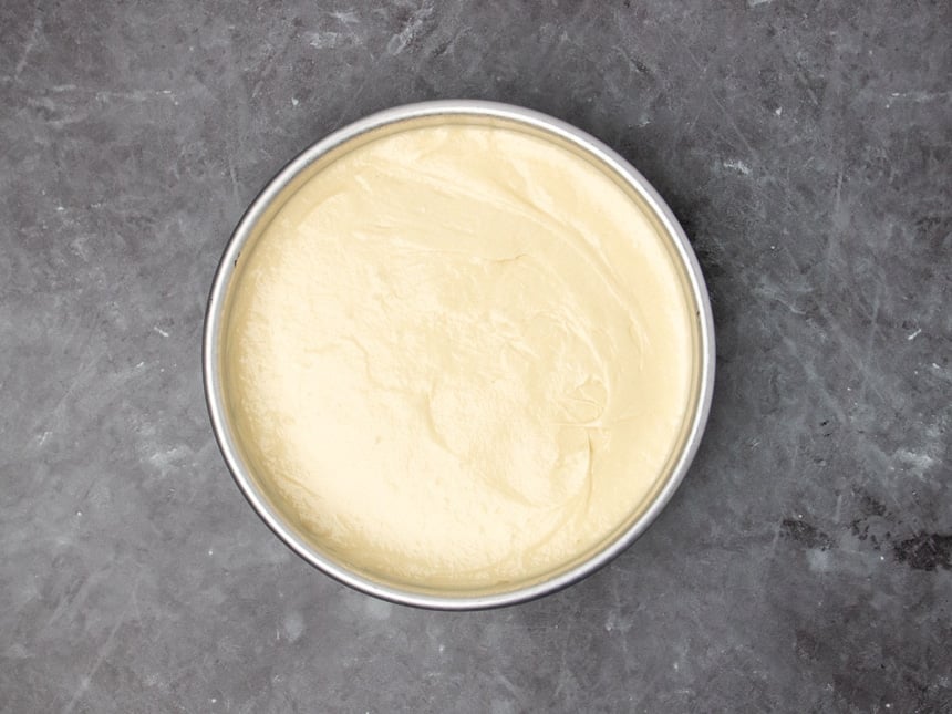 round metal cake pan with light yellow batter in an even layer
