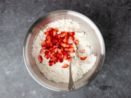 same bowl with butter shreds mixed in and chopped bright red strawberries