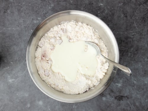 mixture in same bowl with white liquid buttermilk on top