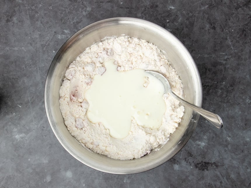 mixture in same bowl with white liquid buttermilk on top