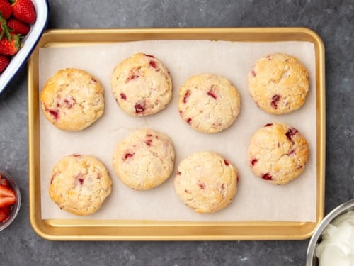 same biscuits on same baking sheet on white paper after biscuits have been baked and are lightly golden brown