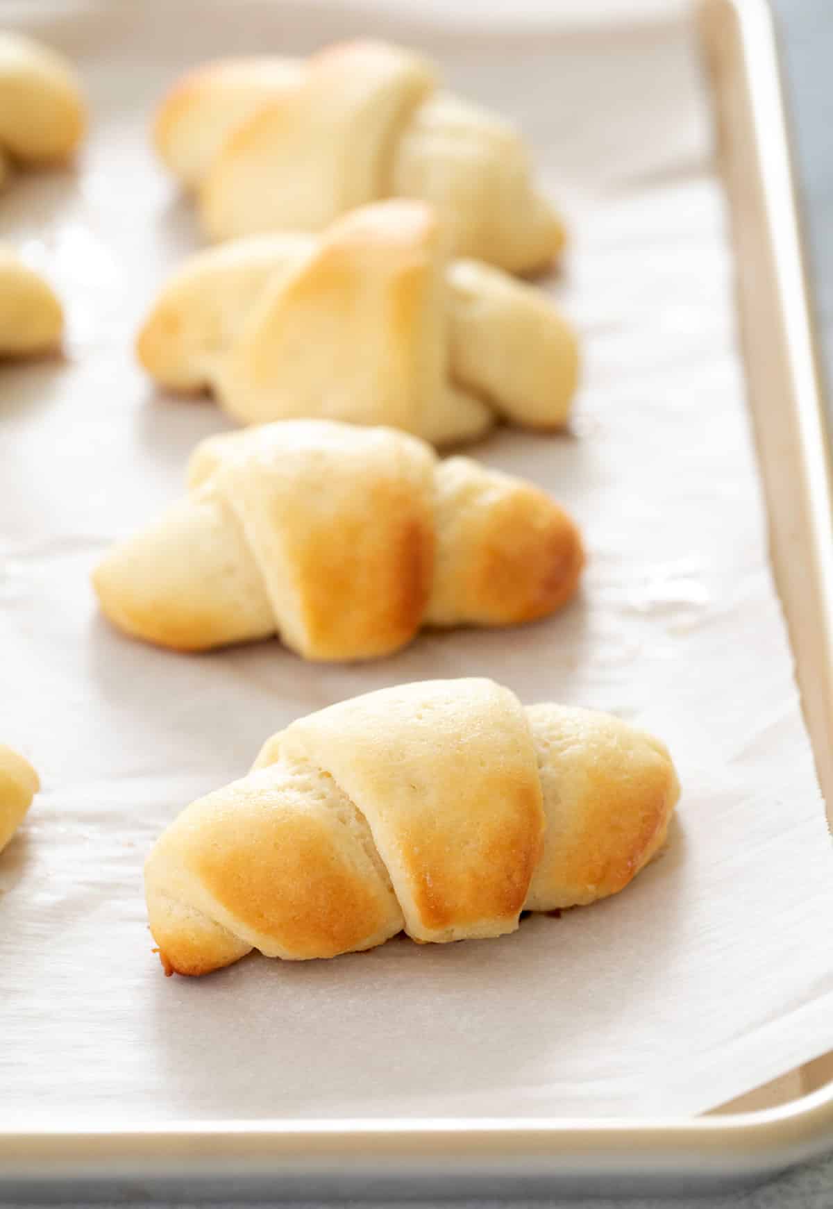 Crescent rolls baked on white paper on tray