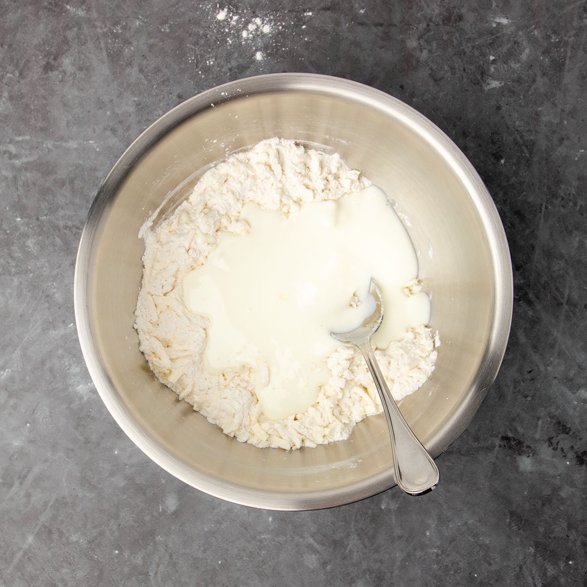 same bowl with flour and butter with white buttermilk on top