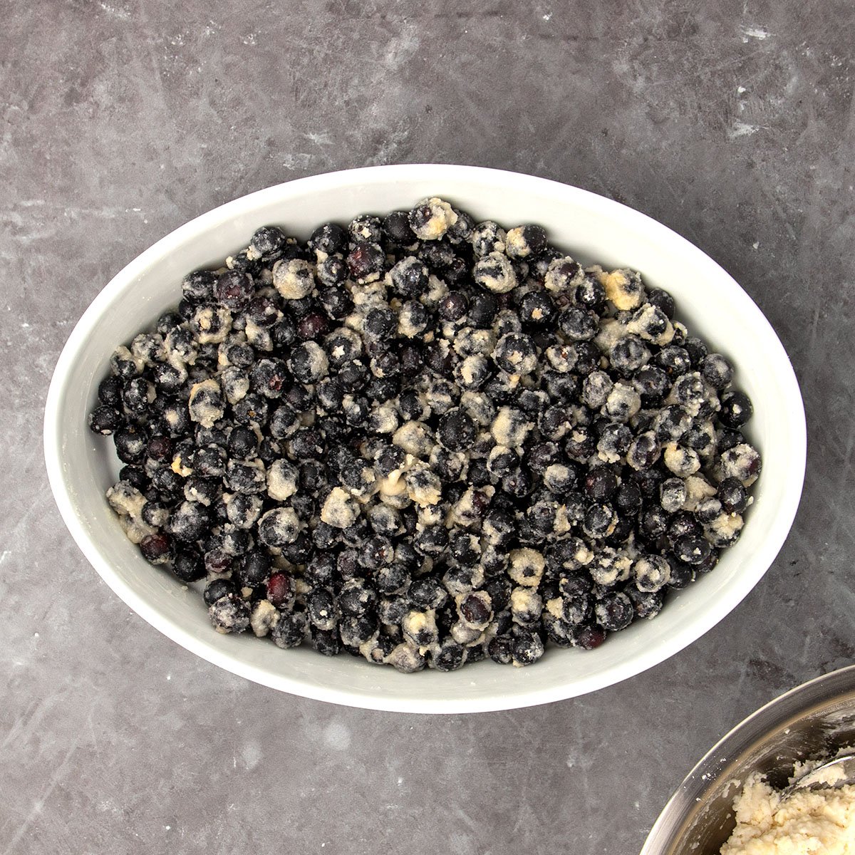 white oval baking dish with blueberry mixture in single layer