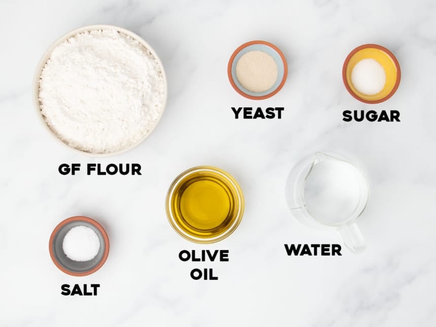ingredients for gluten free pizza dough recipe in small bowls and containers with black block letters spelling out name of each