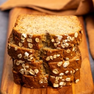 stack of 4 slices of oat flour banana bread on brown cutting board
