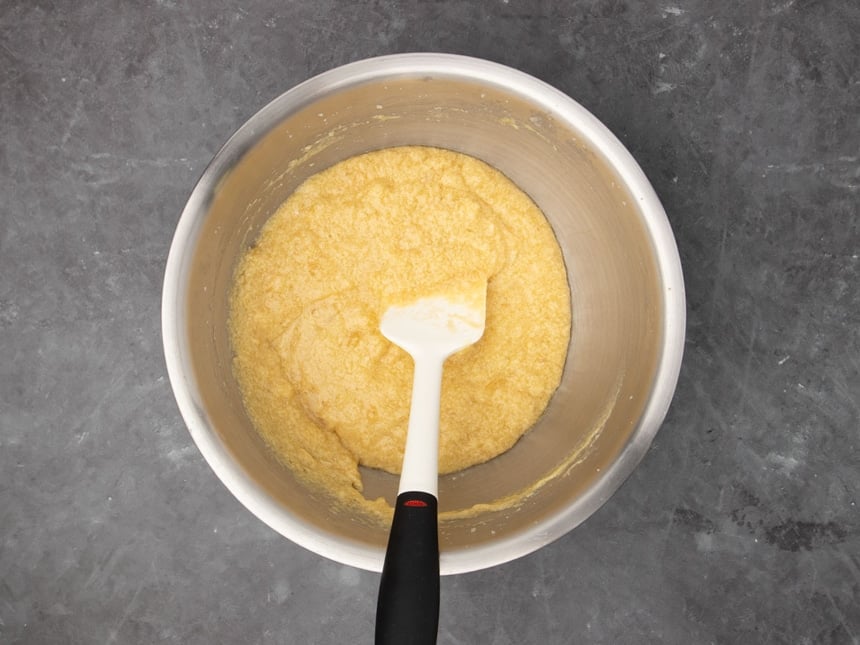 The same mixture now darker was added the crushed bananas, with a white spatula with a black handle