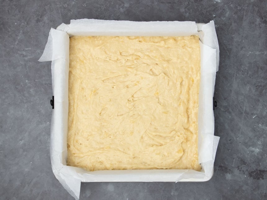 Light yellow picca in square pan covered with white parchment paper