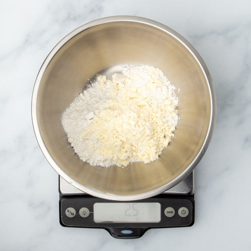 same bowl with light yellow powder on top of white powder on the same scale reading 25 grams
