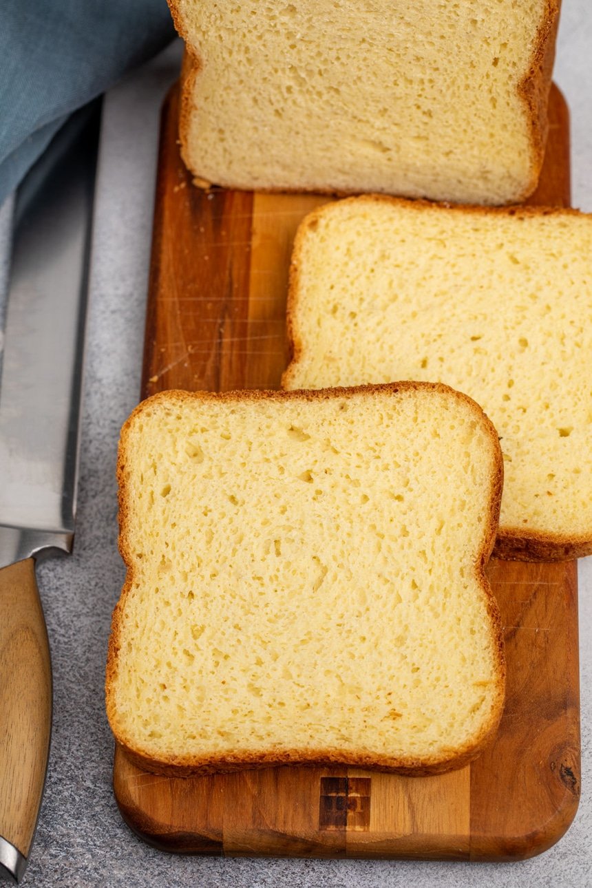 2 individual slices of sandwich bread on brown cutting board on gray surface