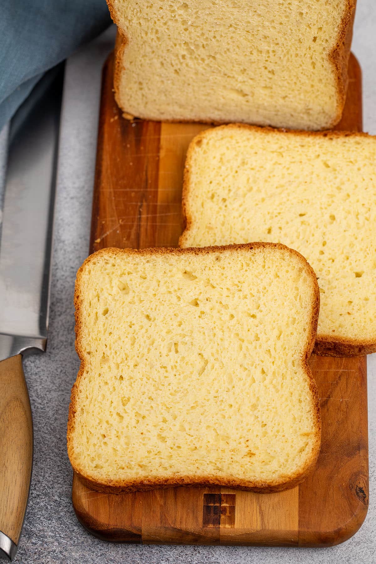 2 individual slices of sandwich bread on brown cutting board on gray surface