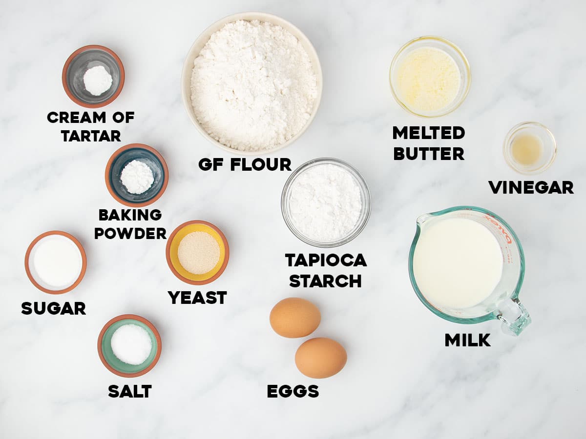 ingredients for gluten free bread machine recipe in small bowls with black block letters spelling name of each ingredient