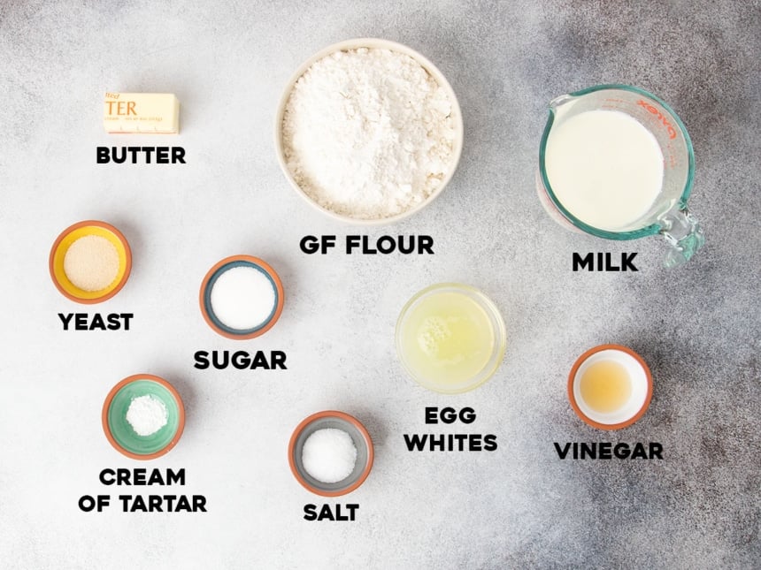 ingredients for gluten free bread recipe in small bowls with black block letters spelling out name of each ingredient