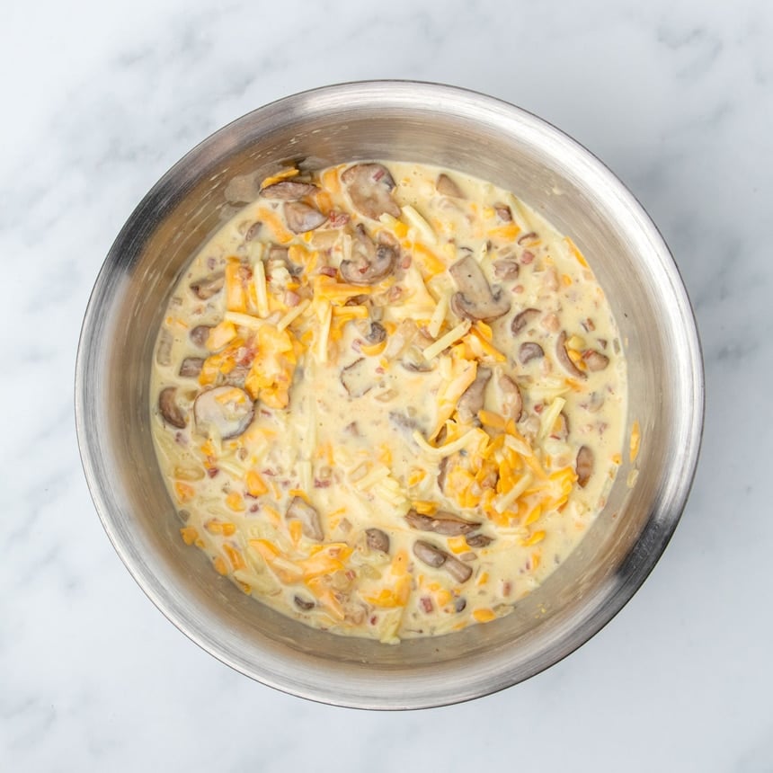 same mixing bowl now with cooked mushrooms, onions and cubed pancetta mixed in