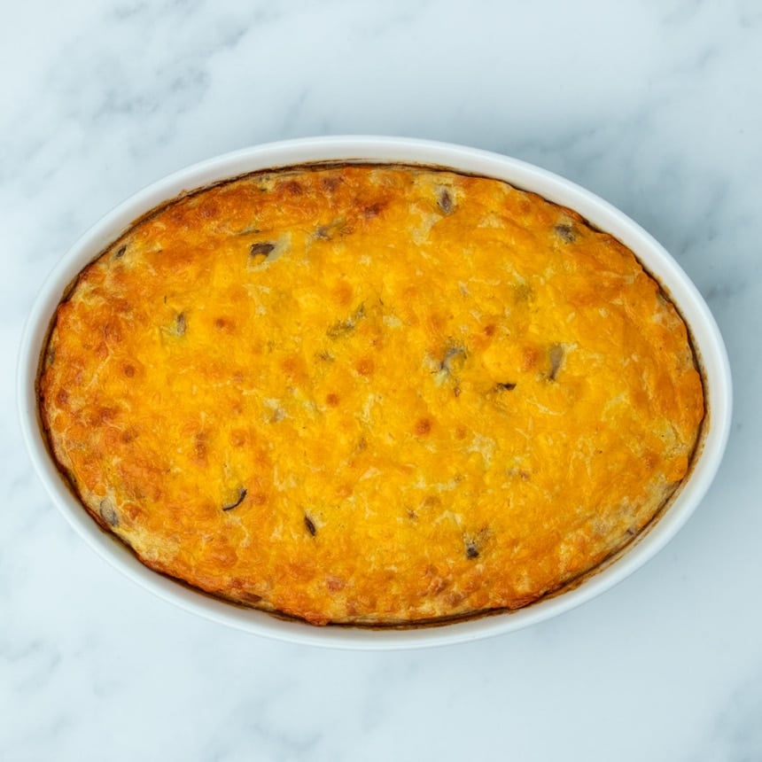 overhead image of white casserole dish with orange and browned melted cheese on top of cooked casserole