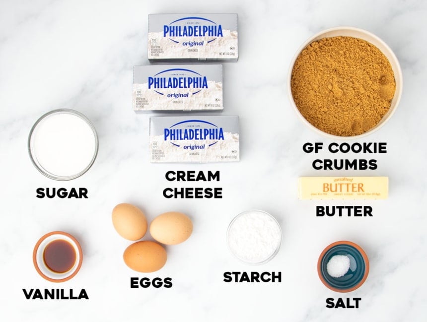 gluten free cheesecake ingredients in small bowls with black block lettering with name of each ingredient