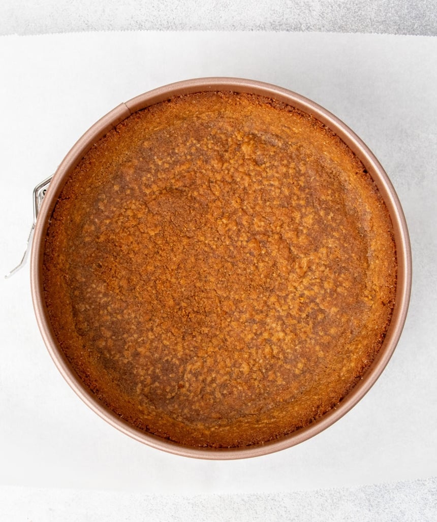 baked brown graham cracker crust in round gold springform pan