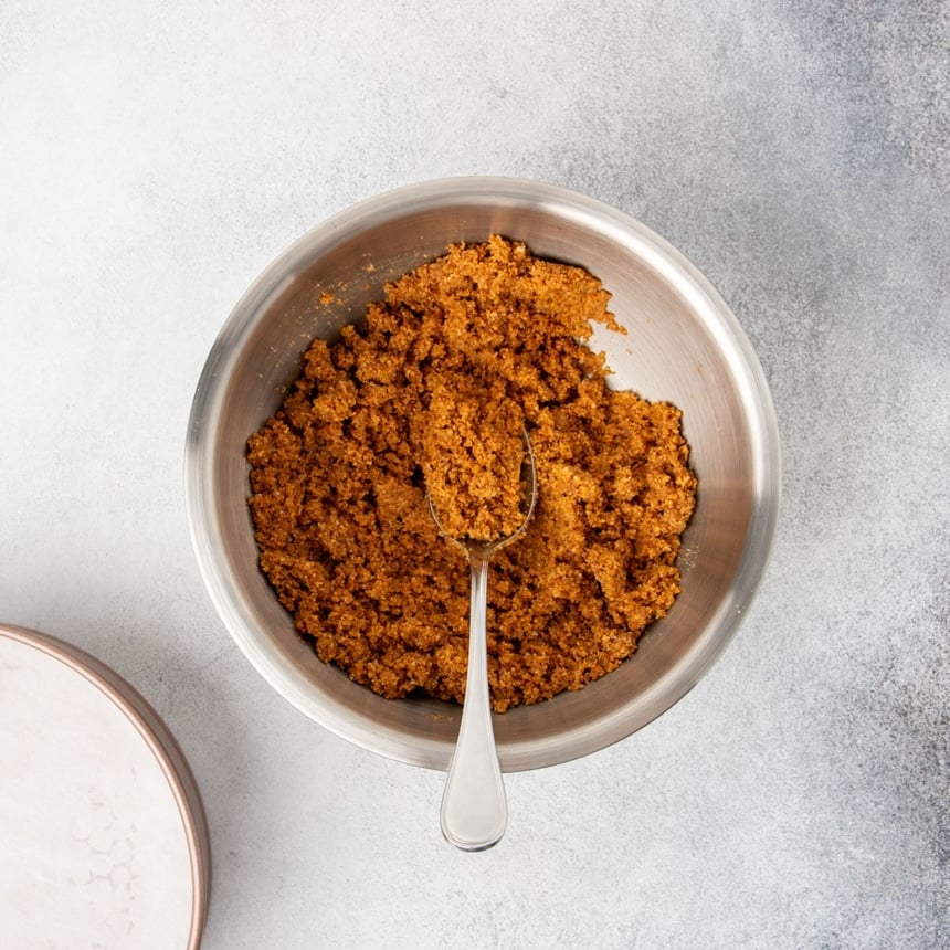 same mixing bowl with everything mixed together with a large metal spoon into dark brown wet clumps