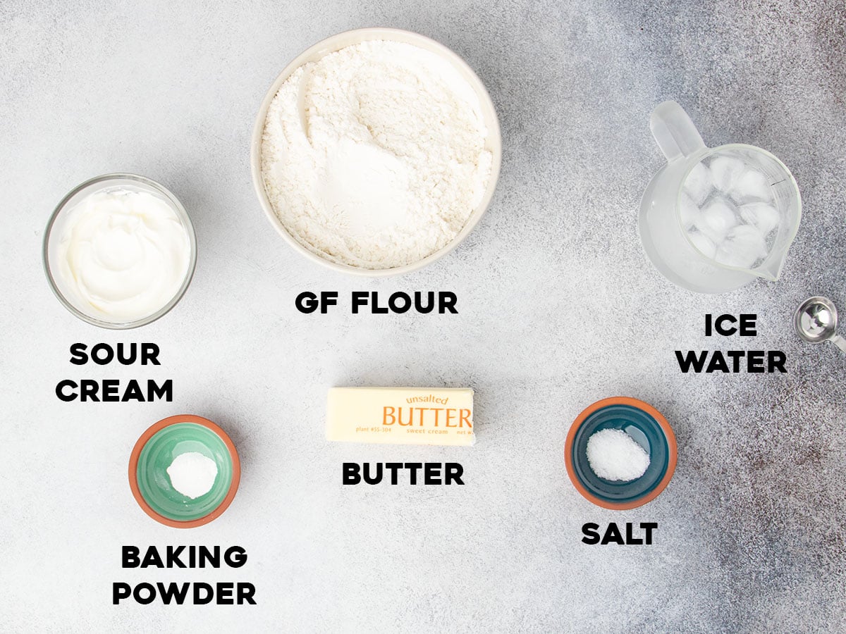 ingredients for gluten free pie crust in small bowls with black block letters spelling out the name of each ingredient