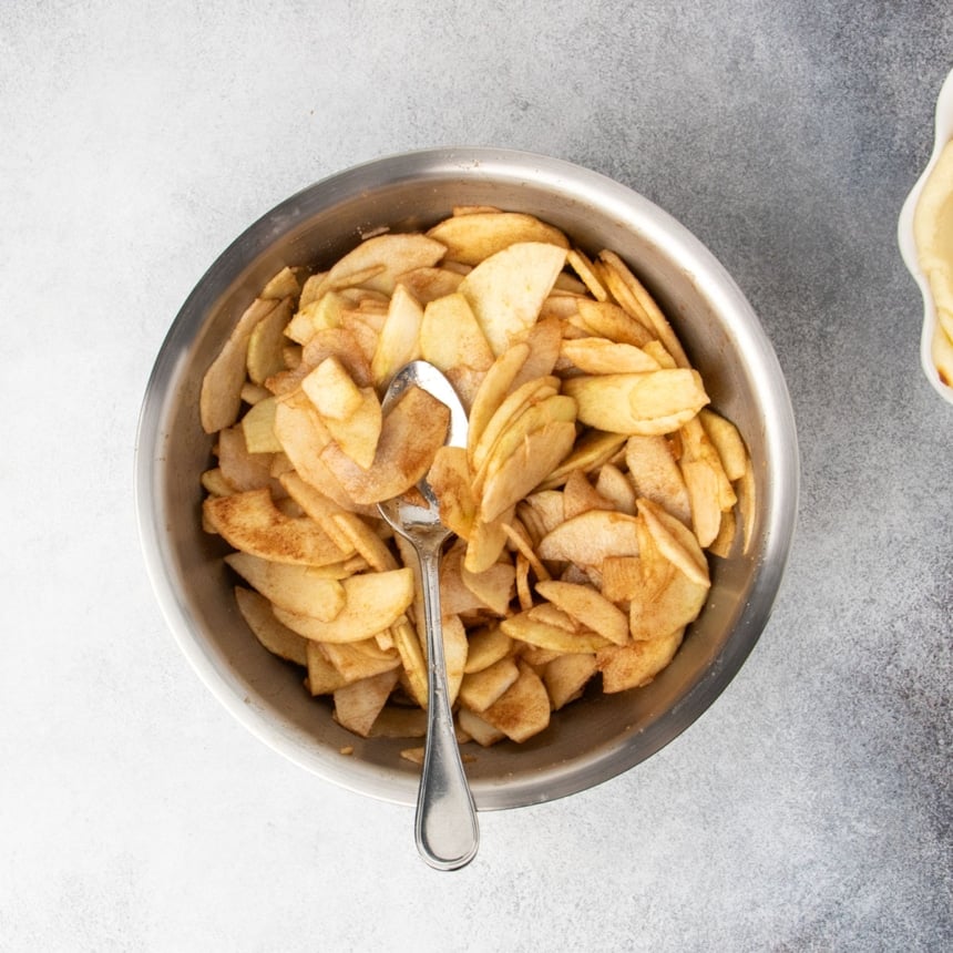 Same apple slices tossed with sugar and cinnamon, ready to be added to the pie crust.