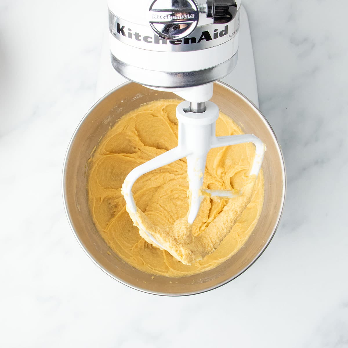 Smooth butter, sugars and egg mixture in stand mixer bowl with white paddle attachment, without chips or gluten free flour.