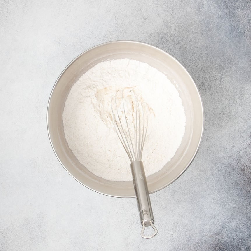 Dry ingredients for rolls whisked together in a large mixing bowl.