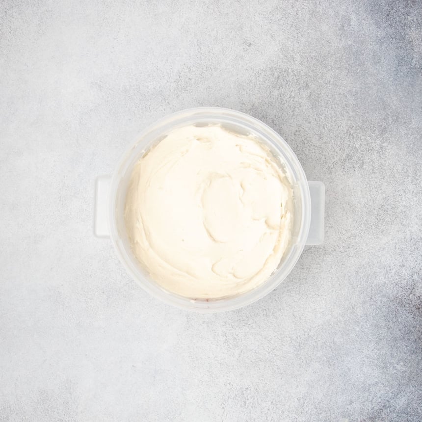 Smooth raw gluten free dough placed in a container, ready to proof.