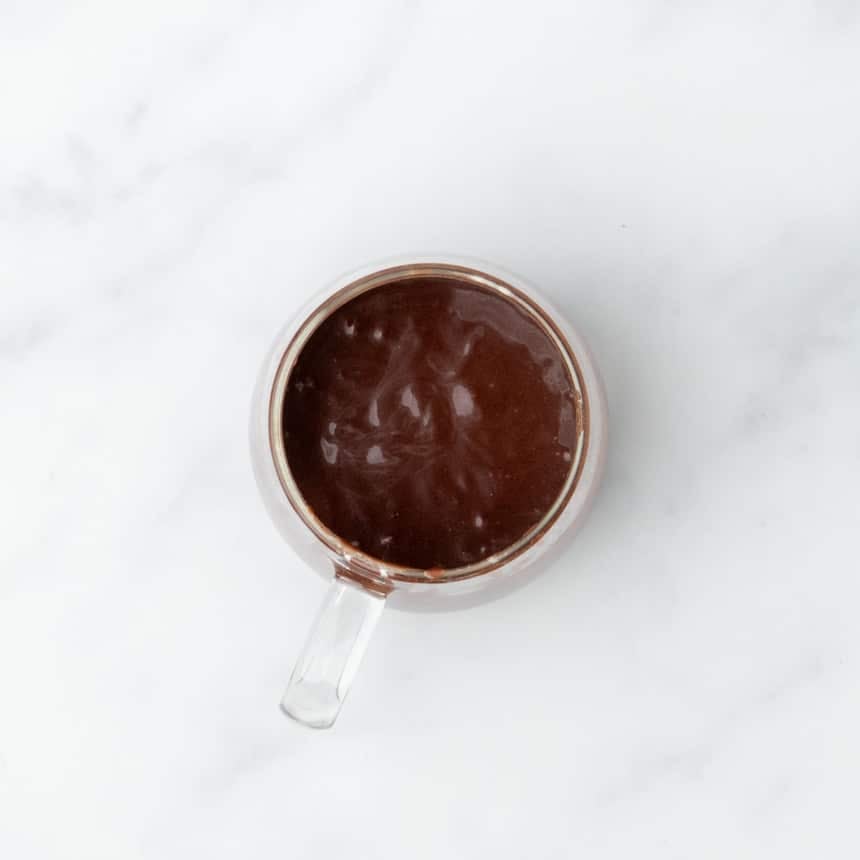 Glass mug filled with thick, glossy batter just before cooking.