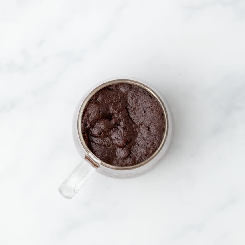 Baked gluten free mug cake with a rich texture, still in the glass mug.