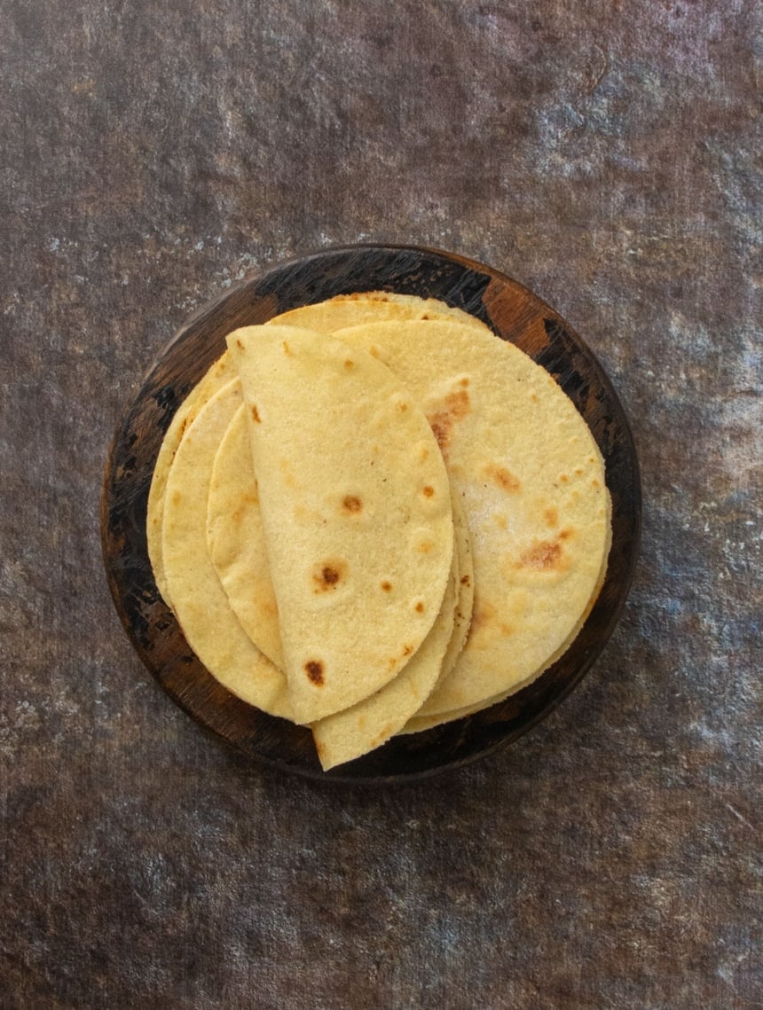 Top-down view of golden tortillas arranged neatly on a dark background