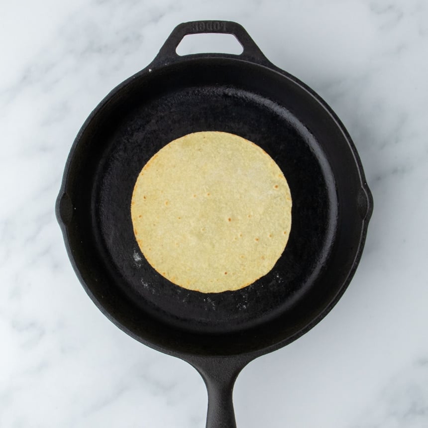 Lightly golden almond flour tortilla just after being flipped in skillet