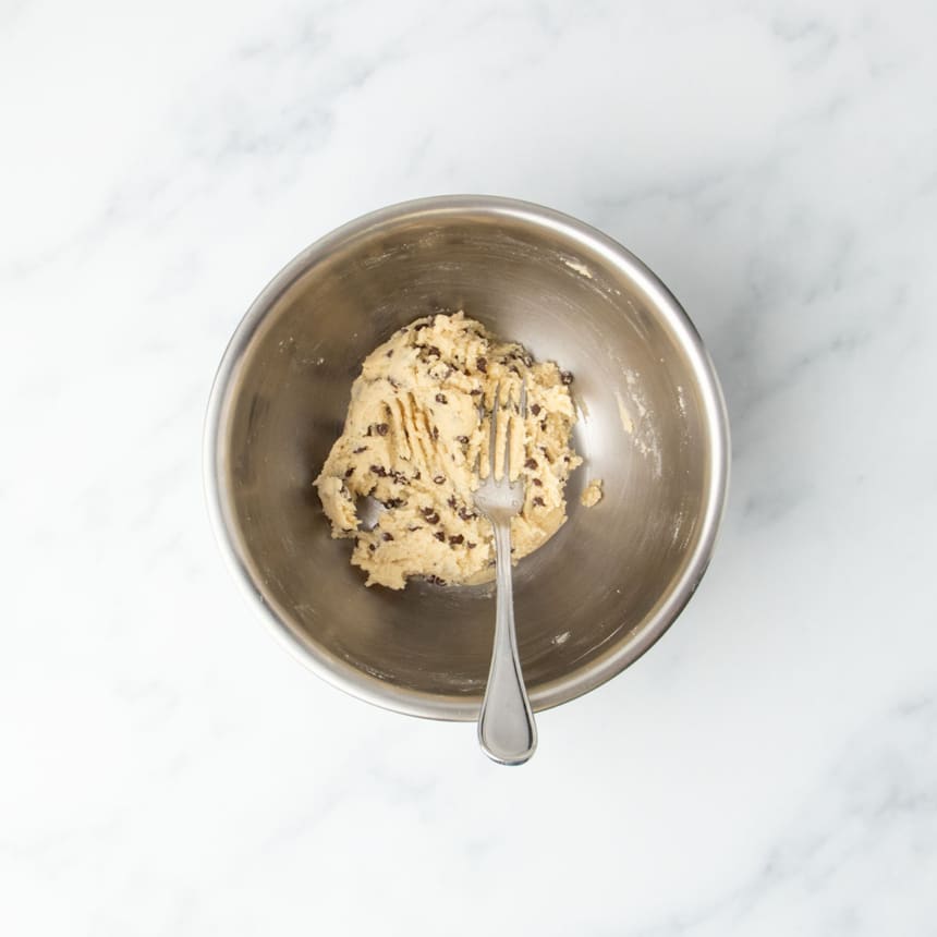 Finished cookie dough in bowl with mini chocolate chips mixed throughout.