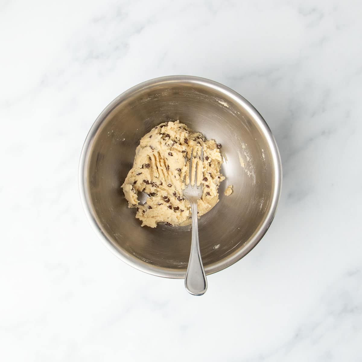 Finished cookie dough in bowl with mini chocolate chips mixed throughout.