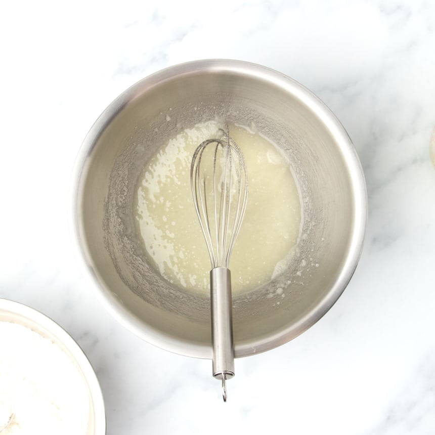 Granulated sugar and neutral oil whisked together in a large stainless steel mixing bowl until well combined and the sugar is dissolved.