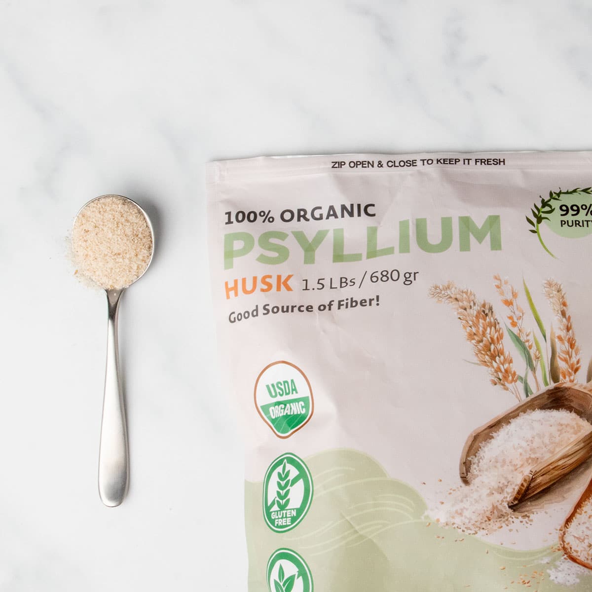 light brown and green package of whole psyllium husk with sample of light brown dry flakes on large metal spoon