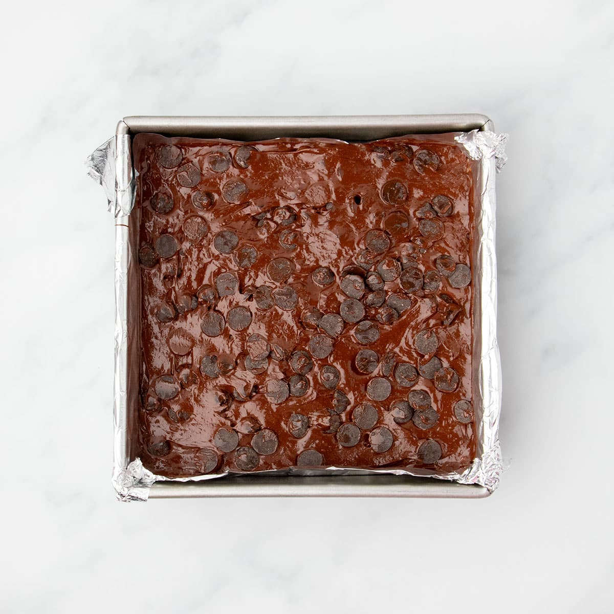 Same raw, shiny brown batter with chocolate chips pressed into the top