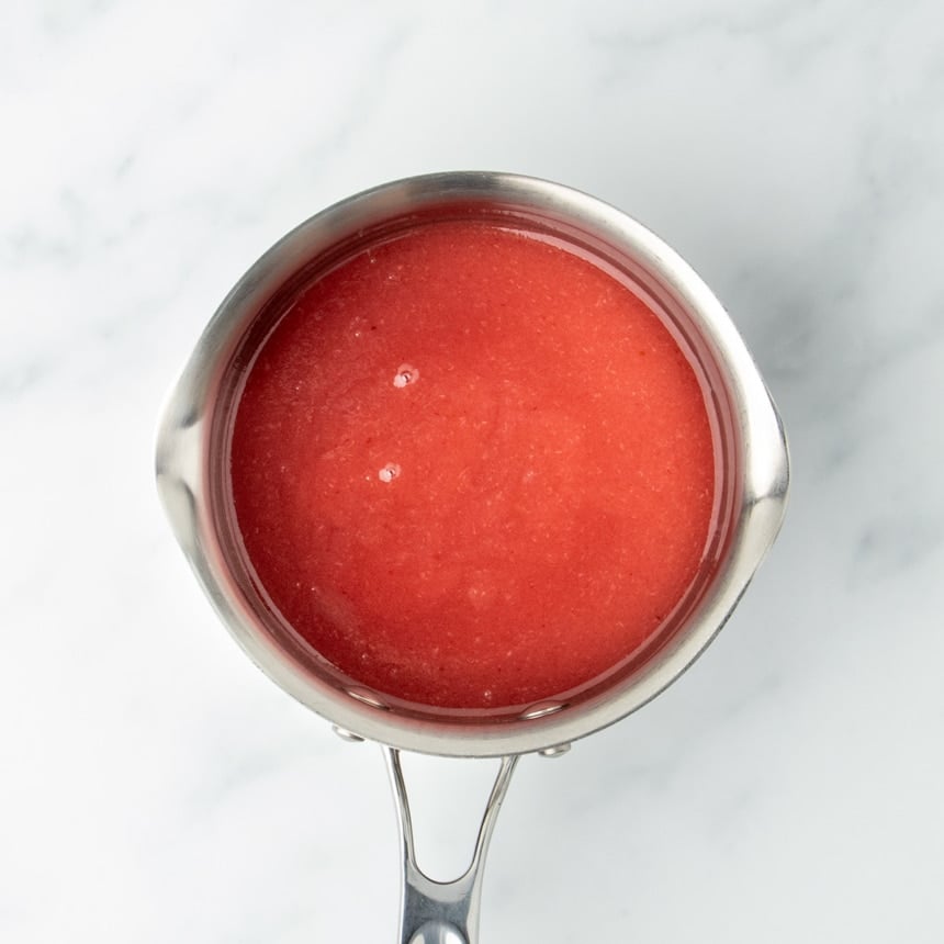 Saucepan filled with bright red strawberry puree