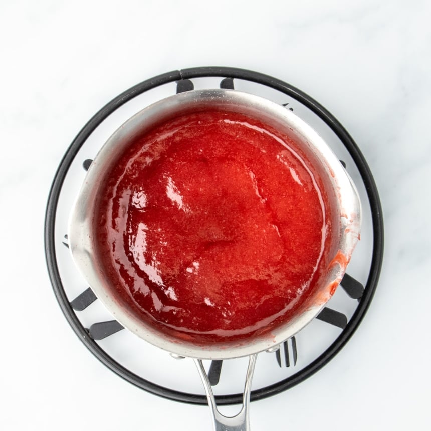 Strawberry puree in a saucepan, thickened and deepened in color after cooking