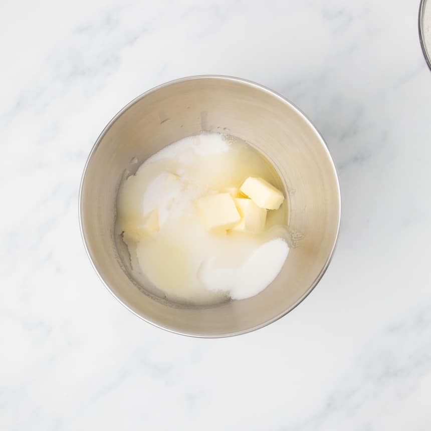 Butter, sugar, and oil measured into a stainless steel mixing bowl