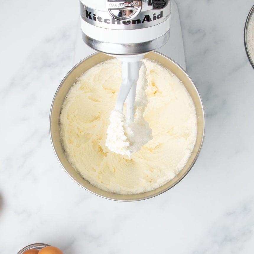 Stand mixer bowl filled with fluffy, creamed butter and sugar.