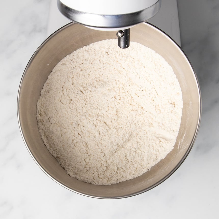 uniform light tan dry ingredient mixture in same round mixing bowl of mixer