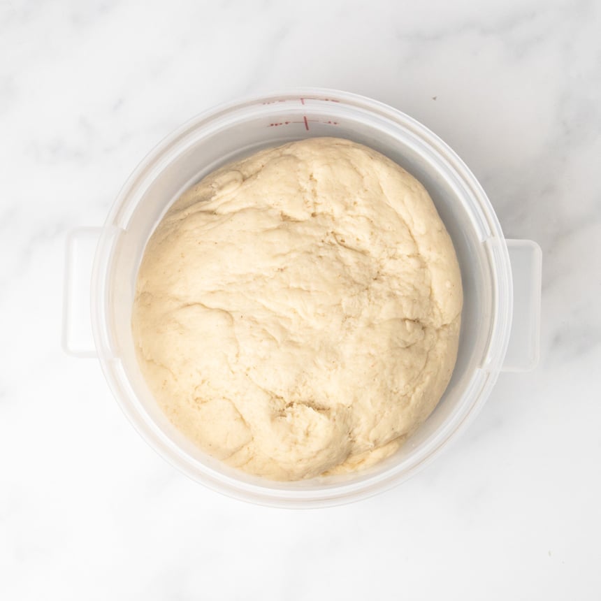 light tan raw soft pretzel bread dough in 2 quart plastic proofing bucket