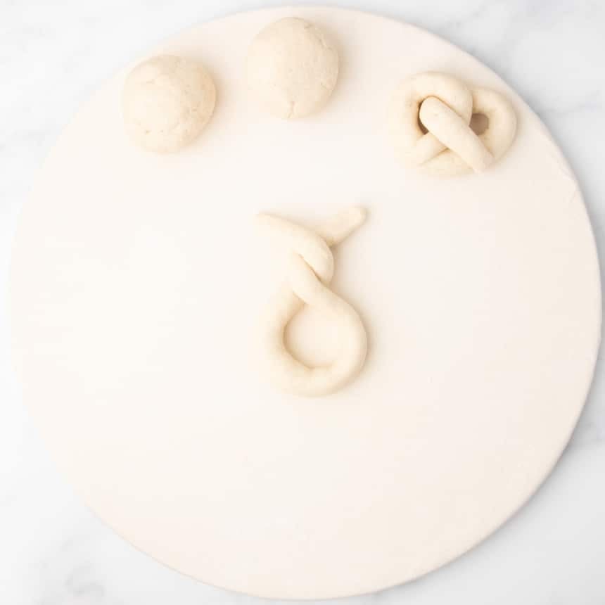 end pieces of crossed loop of rope of raw dough crisscrossed again over one another