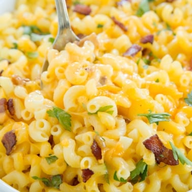cooked gluten free pasta in elbow shape with cheese, parsley and bacon pieces