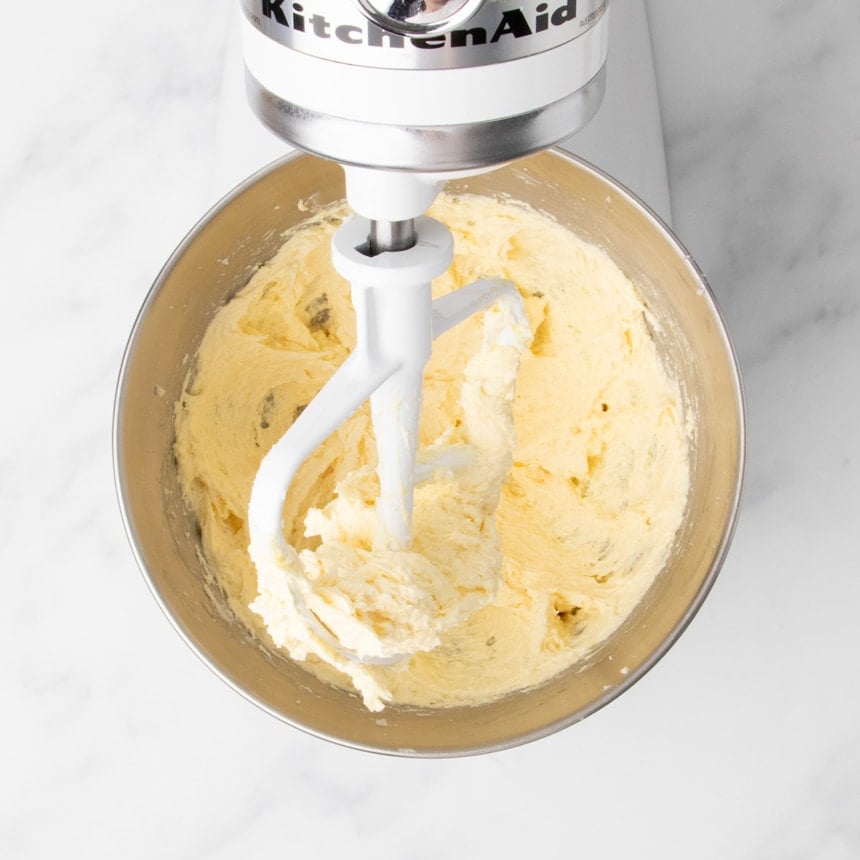 Creamed butter, sugar and egg mixture thickened to a pale yellow batter in the stand mixer bowl.