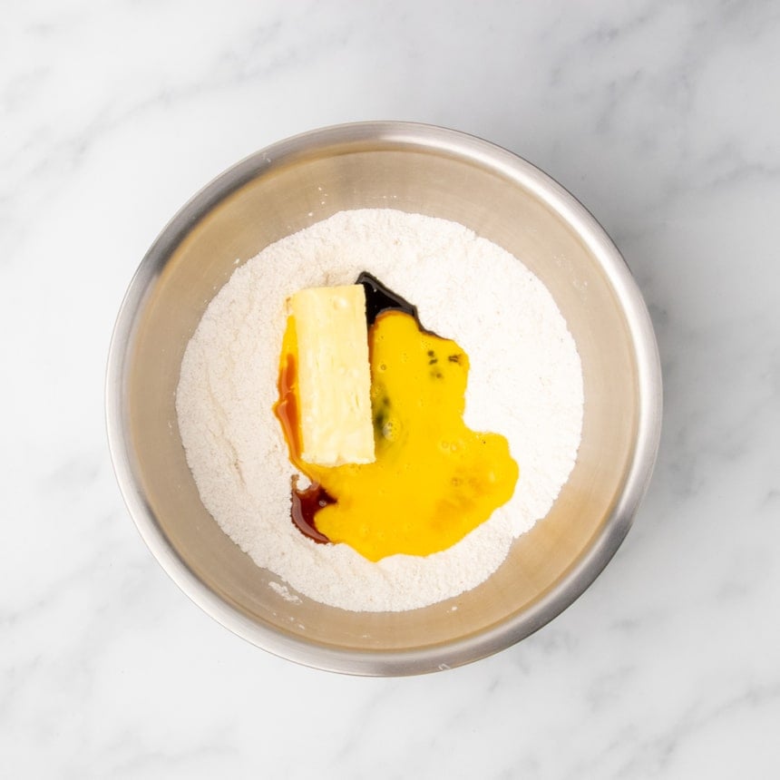 Unmixed butter, beaten egg, and molasses added to dry ingredients in a mixing bowl.