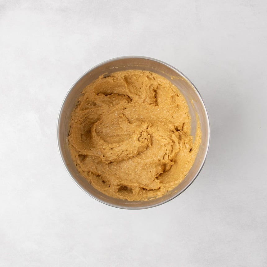 Finished batter resting in a stainless steel mixing bowl, light brown and textured.